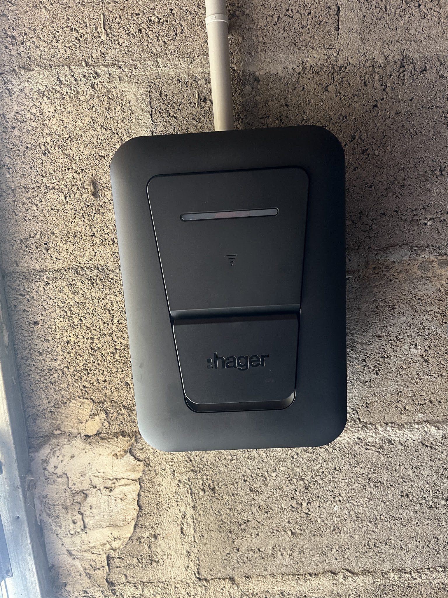 Borne de recharge Hager posée sur un mur en parpaing